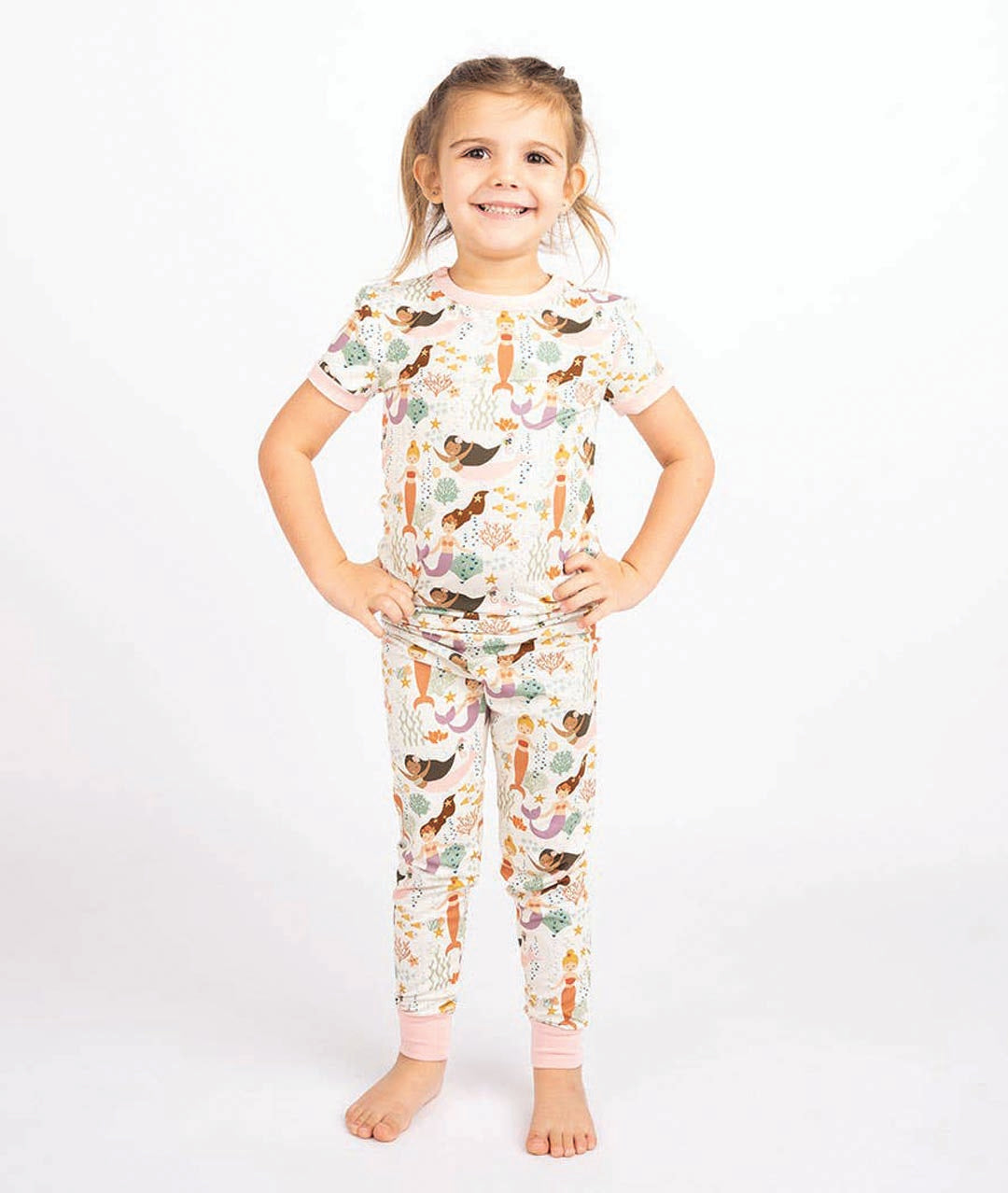 Child wearing a pajama set with a nature-themed print on a white background