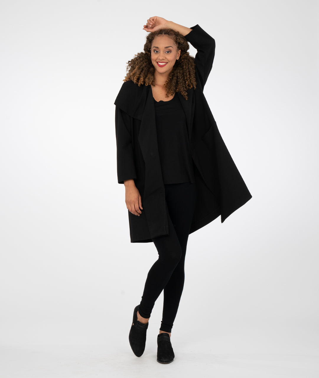model in black leggings with a black asymmetrical jacket with a large collar