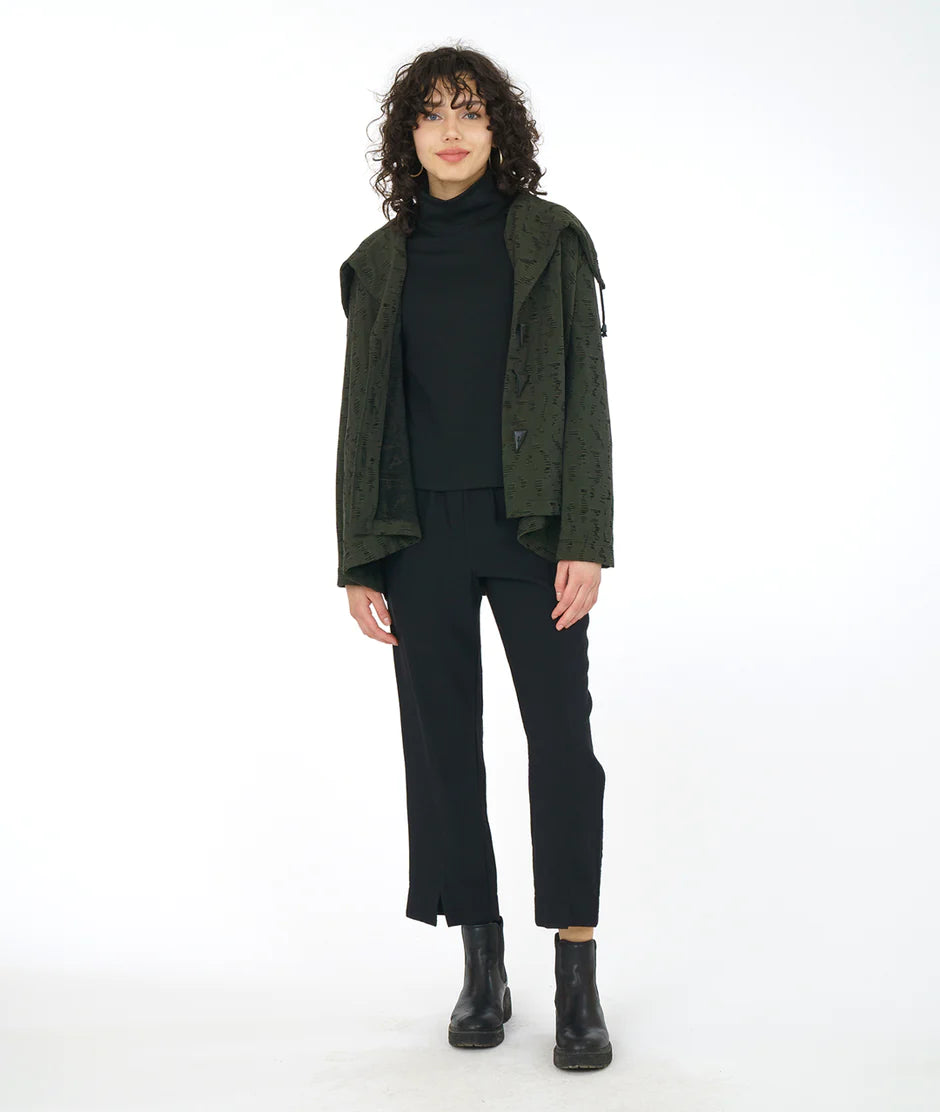 model is wearing a forest green patterned jacket atop an all black outfit