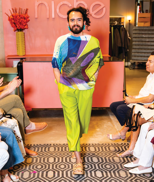 model in a straight leg lime green pant worn with a multi color abstract print top