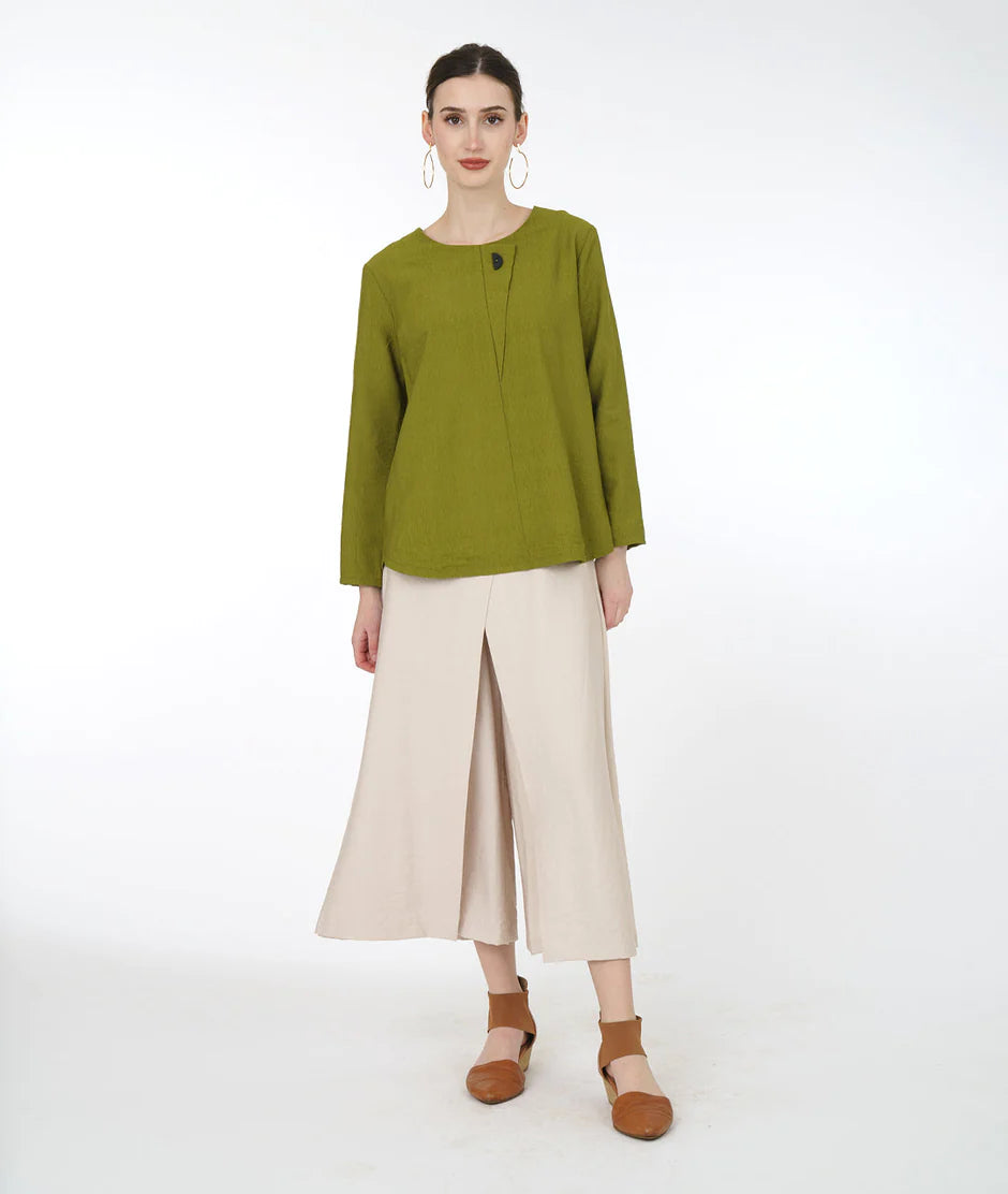 model is wearing a green top and light colored flowy pants against a white background