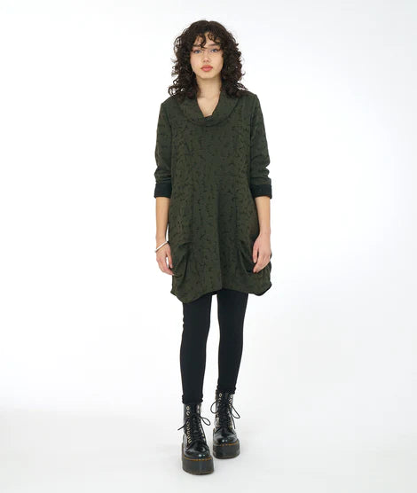 model is wearing a short olive dress with tights and chunky boots