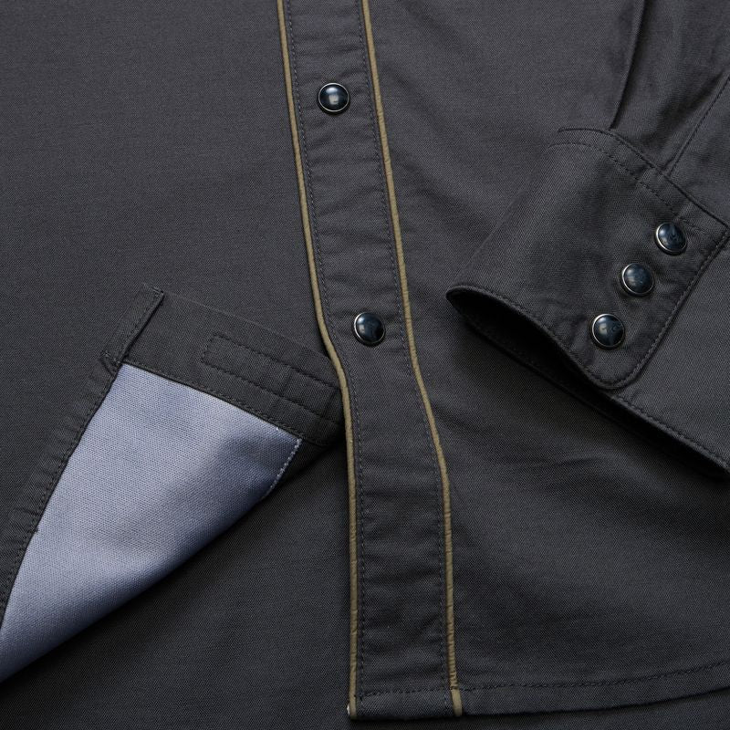 Close-up of a dark charcoal gray button-up shirt with a light gray inner lining on the pocket and a thin tan contrast stitch running down the front placket.
