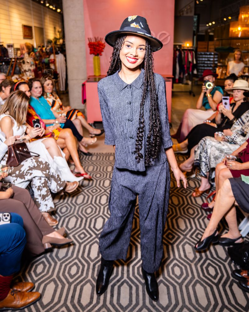 model in a matching grey stripe outfit and hat on a runway