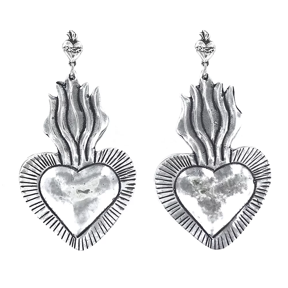 heart shaped milagro silver earring with heart and flame post. on a white backgeound. 