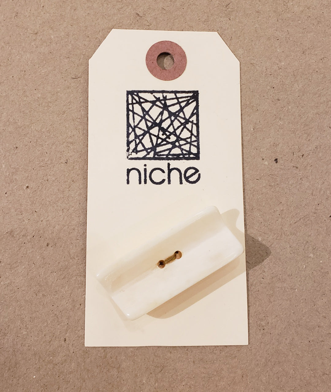 Rectangular white button on a Niche card