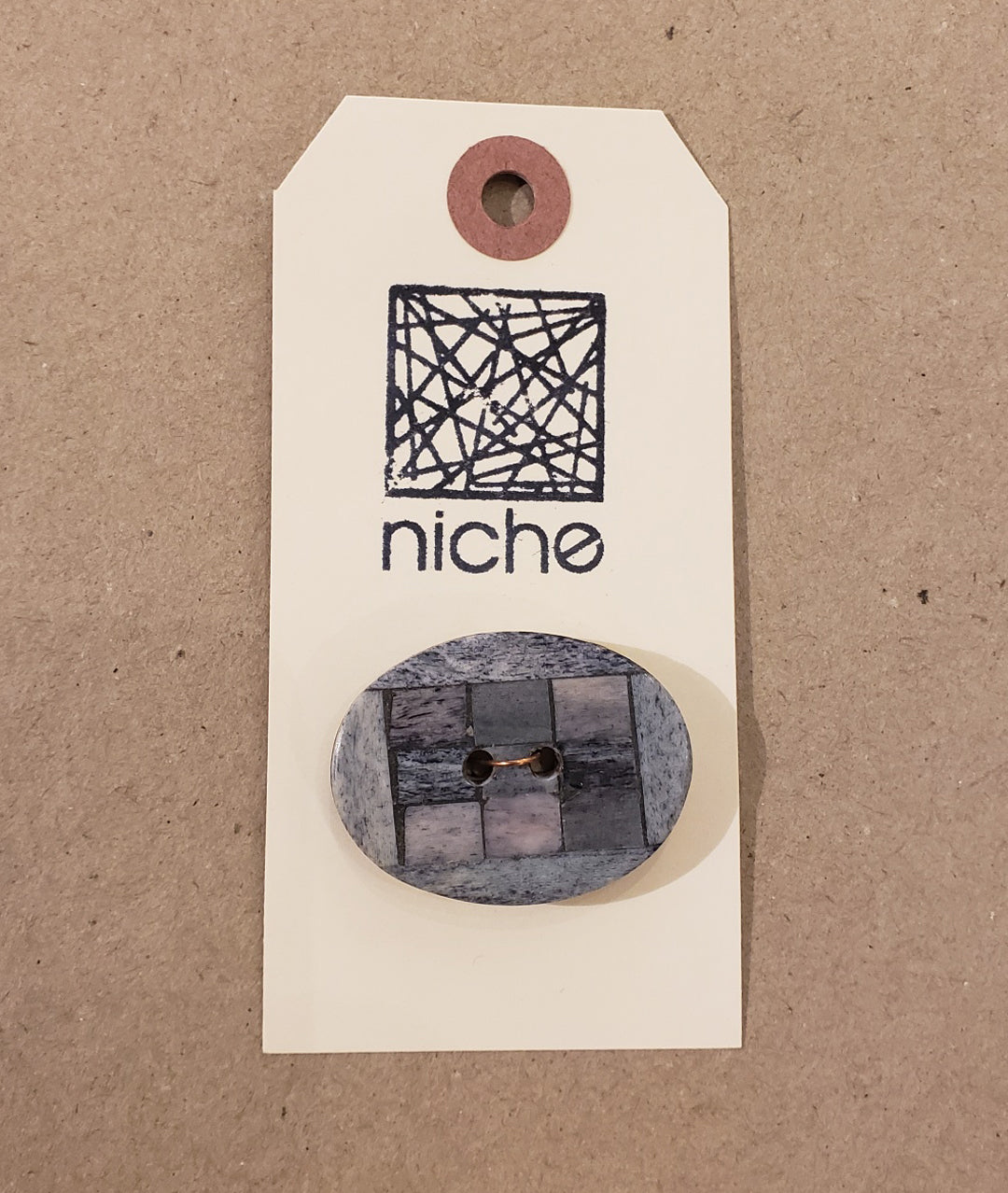 grey button with grid design on Niche card