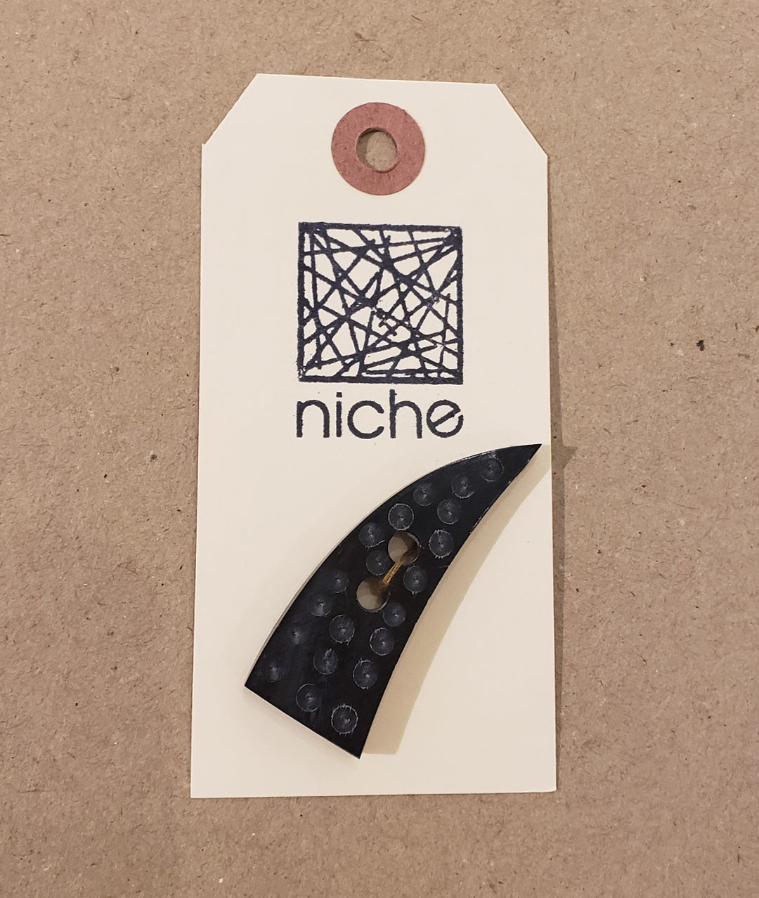 shark tooth dotted black button on a Niche card