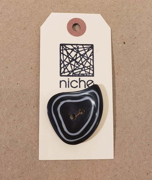 black button with white trim on a Niche card
