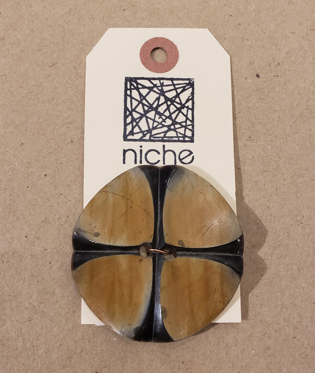 black and brown button on a Niche card