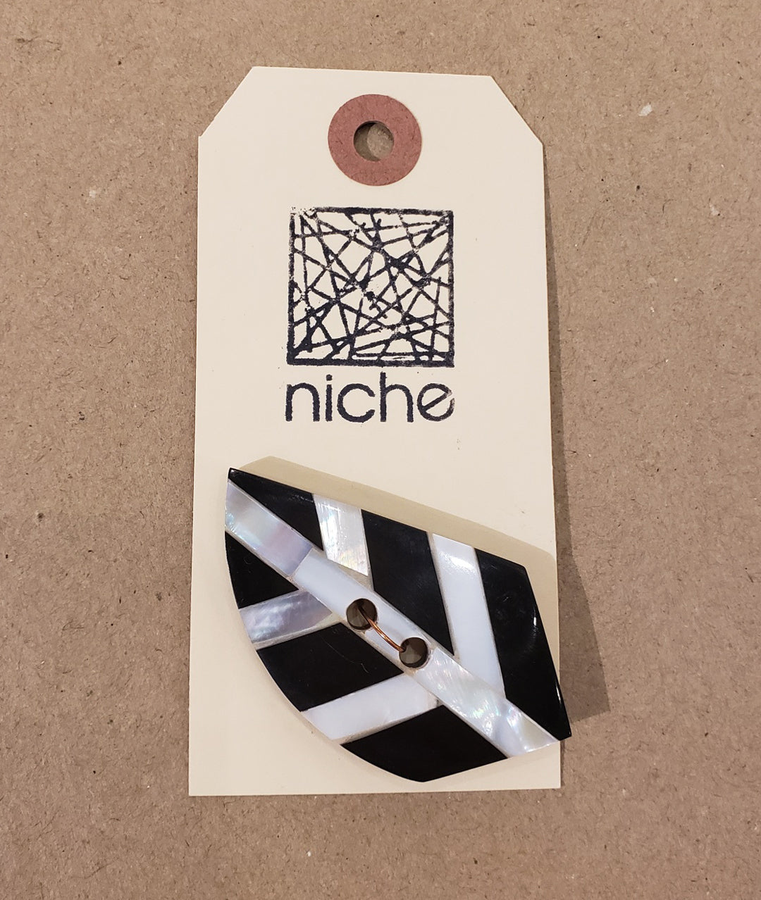 black and white button on Niche card