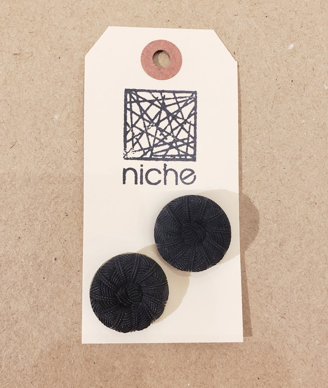 black textured buttons on a Niche card