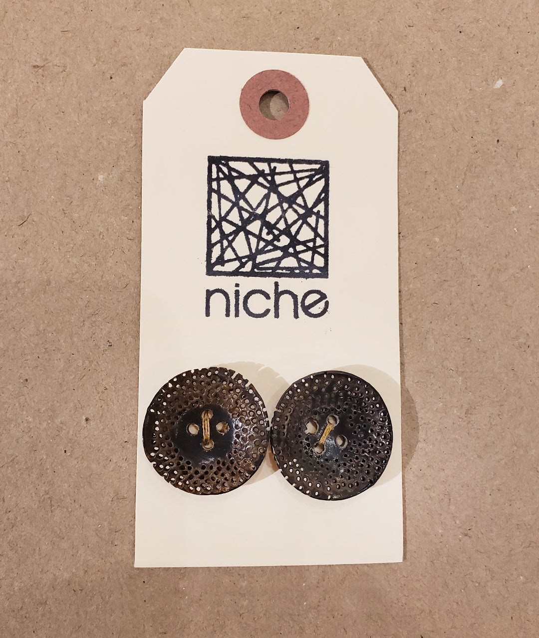 brown dotted buttons on a Niche card
