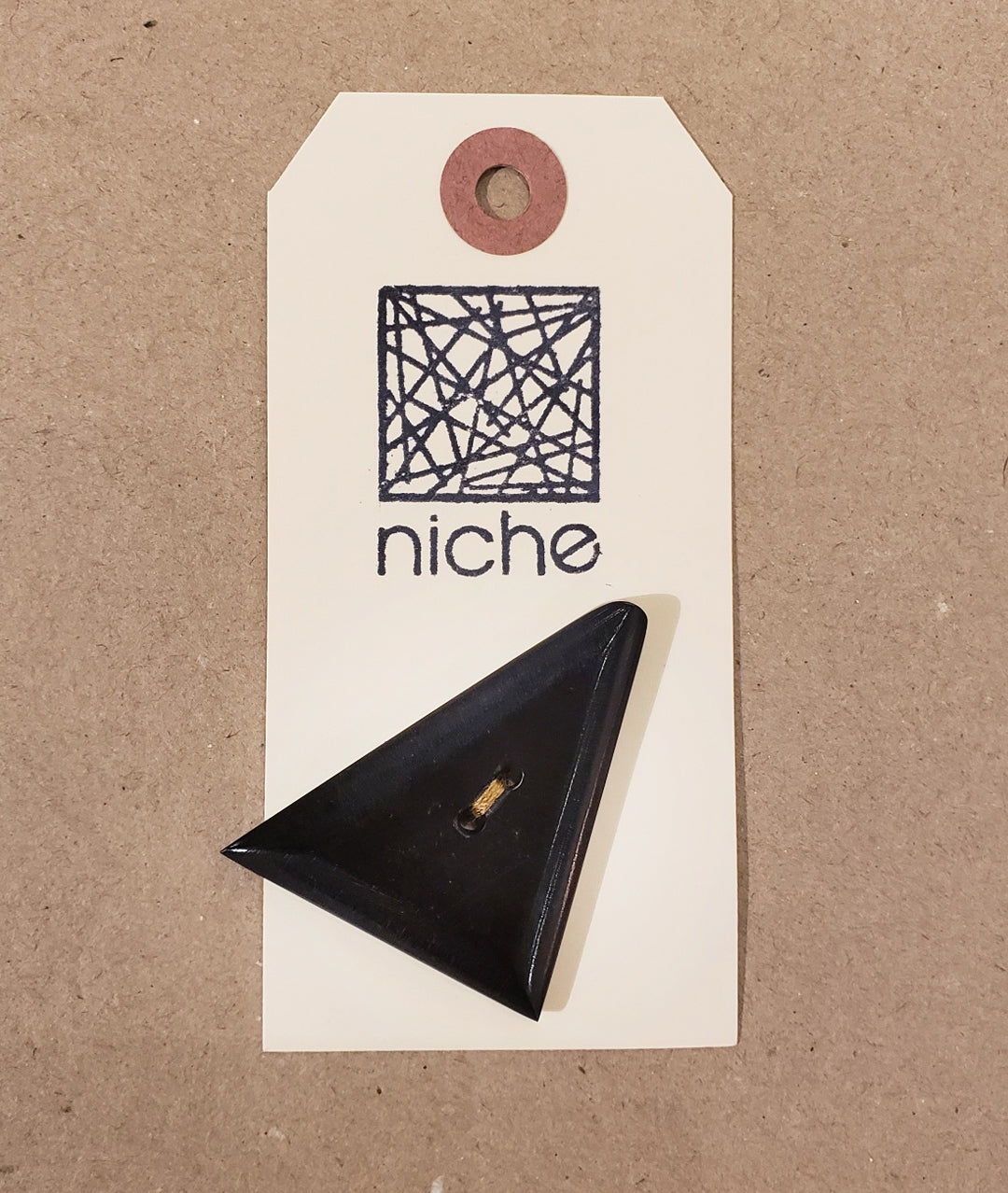 triangular black button on a Niche card