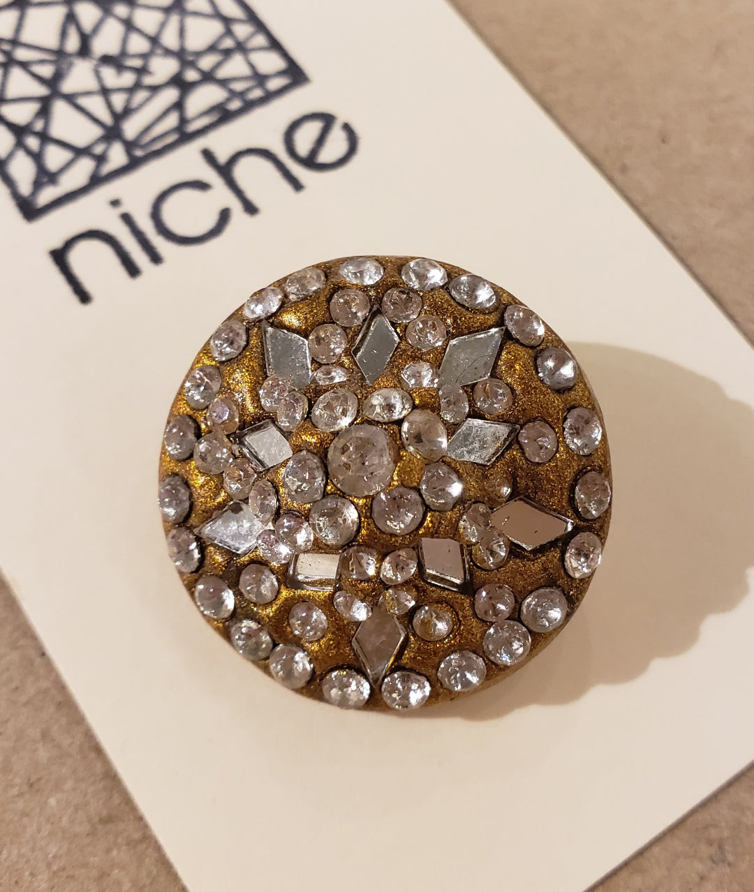 close-up of rhinestone button on a Niche card