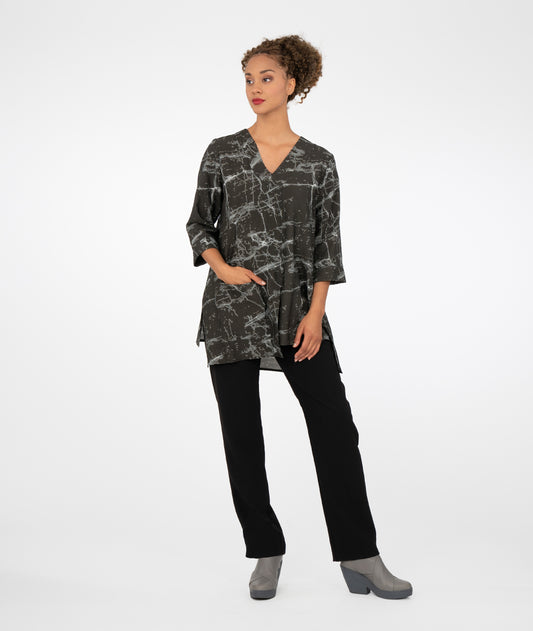 model in a slim black pant with a black marble print tunic with a vneckline, 3/4 sleeves an uneven hemline and a single square pocket on the hip