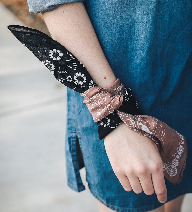 Pictured is a model's arm with the two toned bandana tied around her arm. 