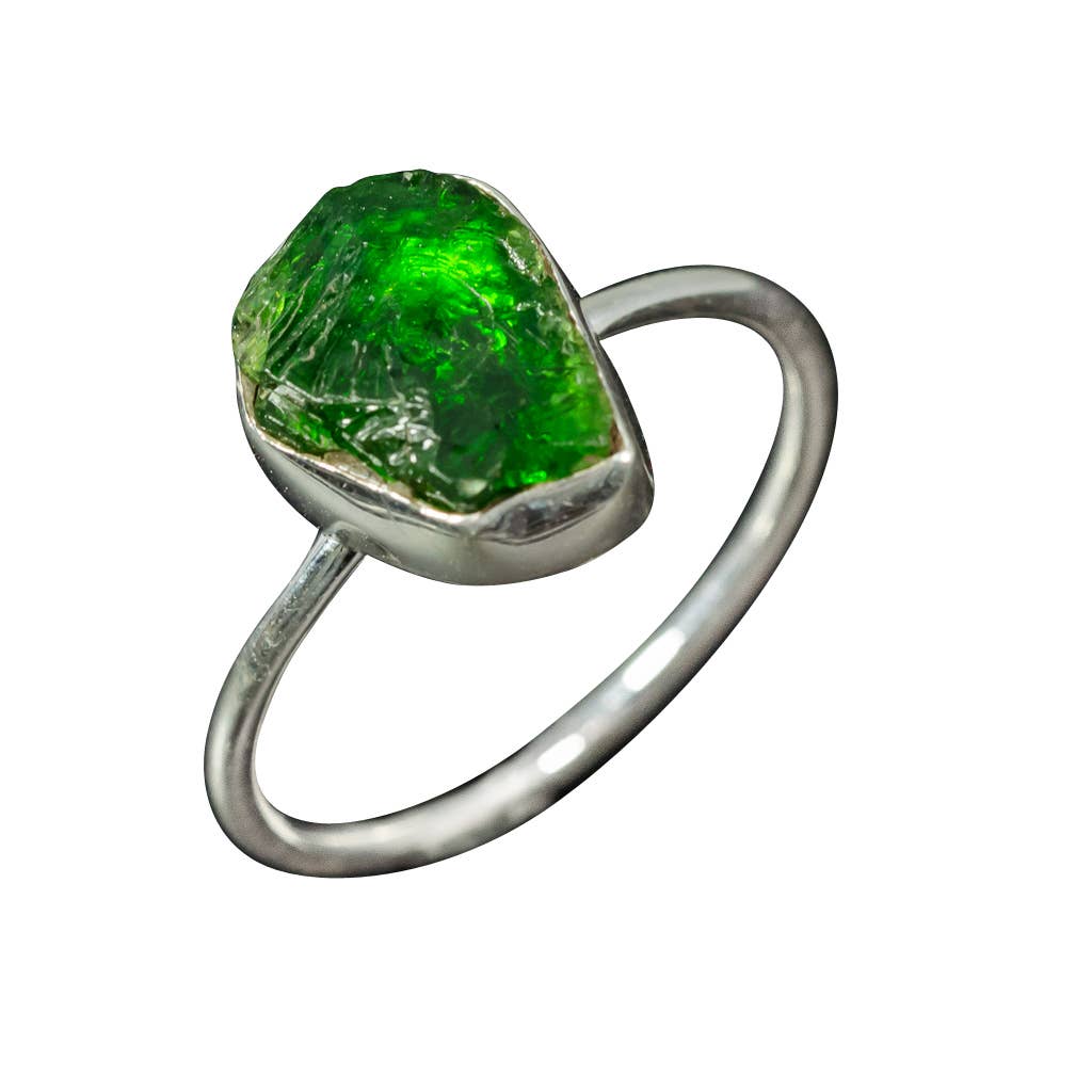 Green tourmaline raw stone sterling silver ring against a white background