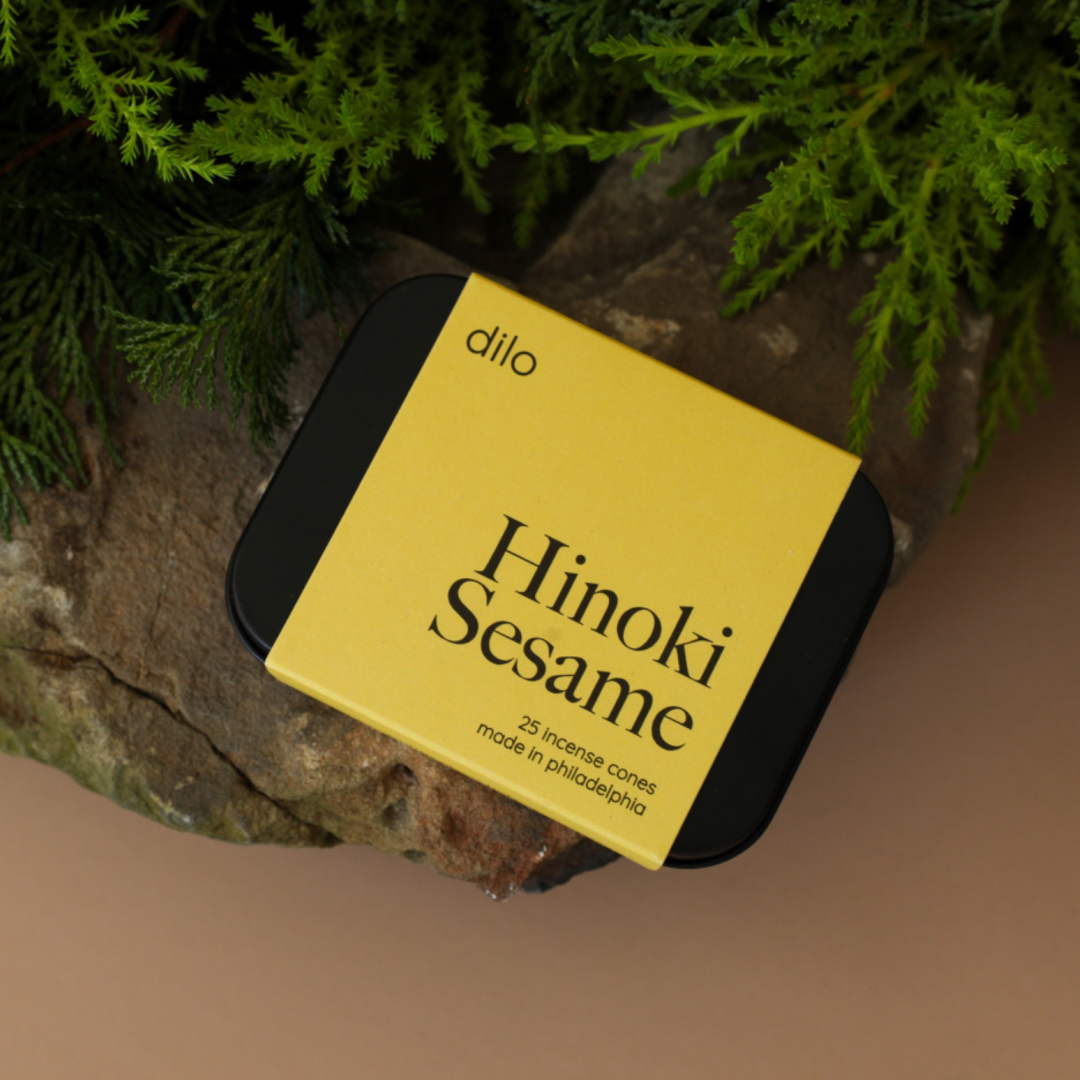 hinoki sesame scented incense cone packaging laying on rock with tree in background