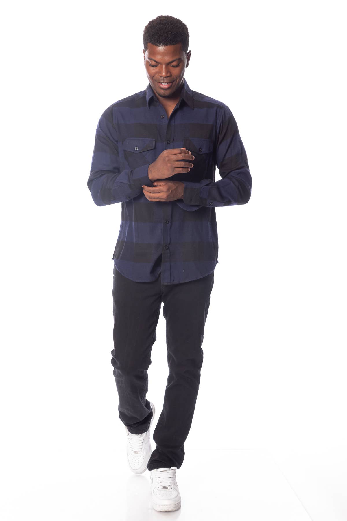 male model wearing a blue & black flannel shirt and black jeans