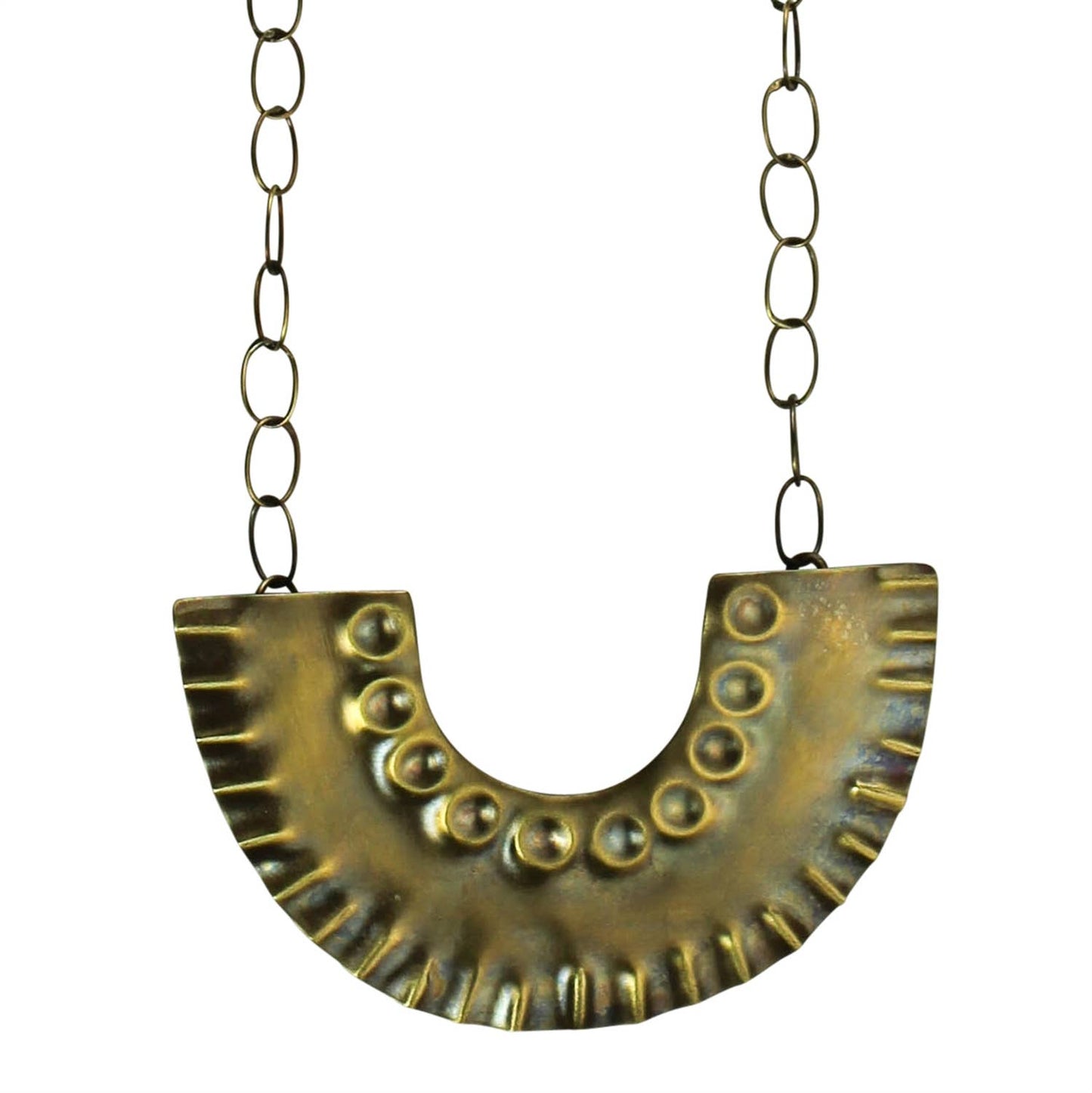 Pictured against a white background is a brass chained necklace that features a crescent "u" shaped pendant that features circles and lines on it.