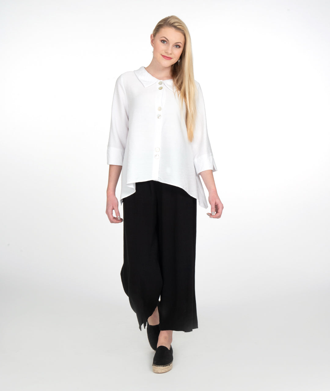 model in a wide leg black pant with a white button up blouse