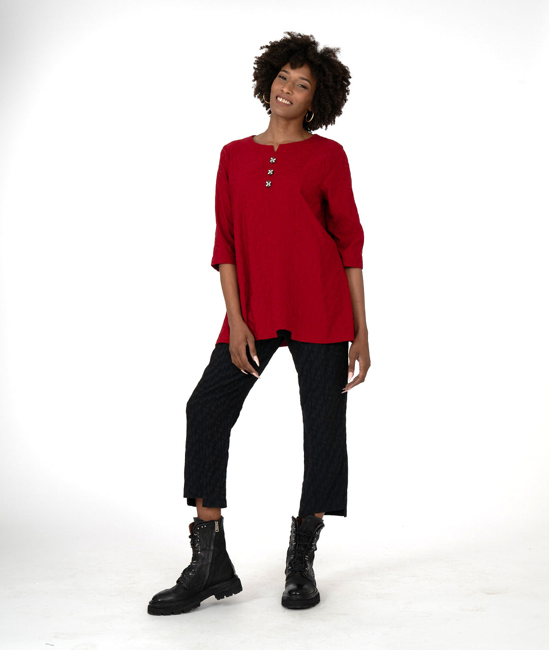 model in a black slim pant and red top, both with asymmetrical hems