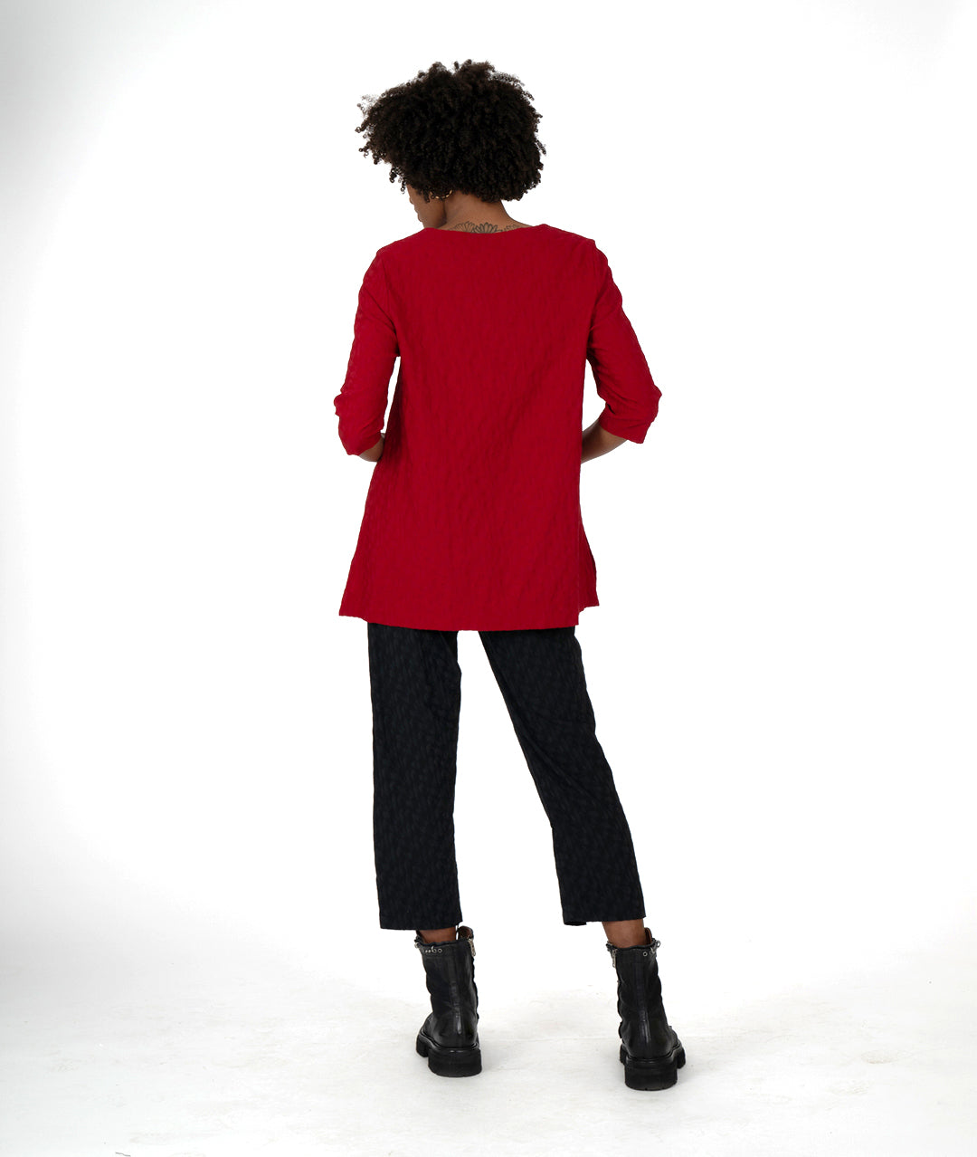 model in a black slim pant and red top, both with asymmetrical hems
