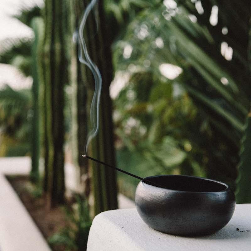 a single incense stick burning outdoors