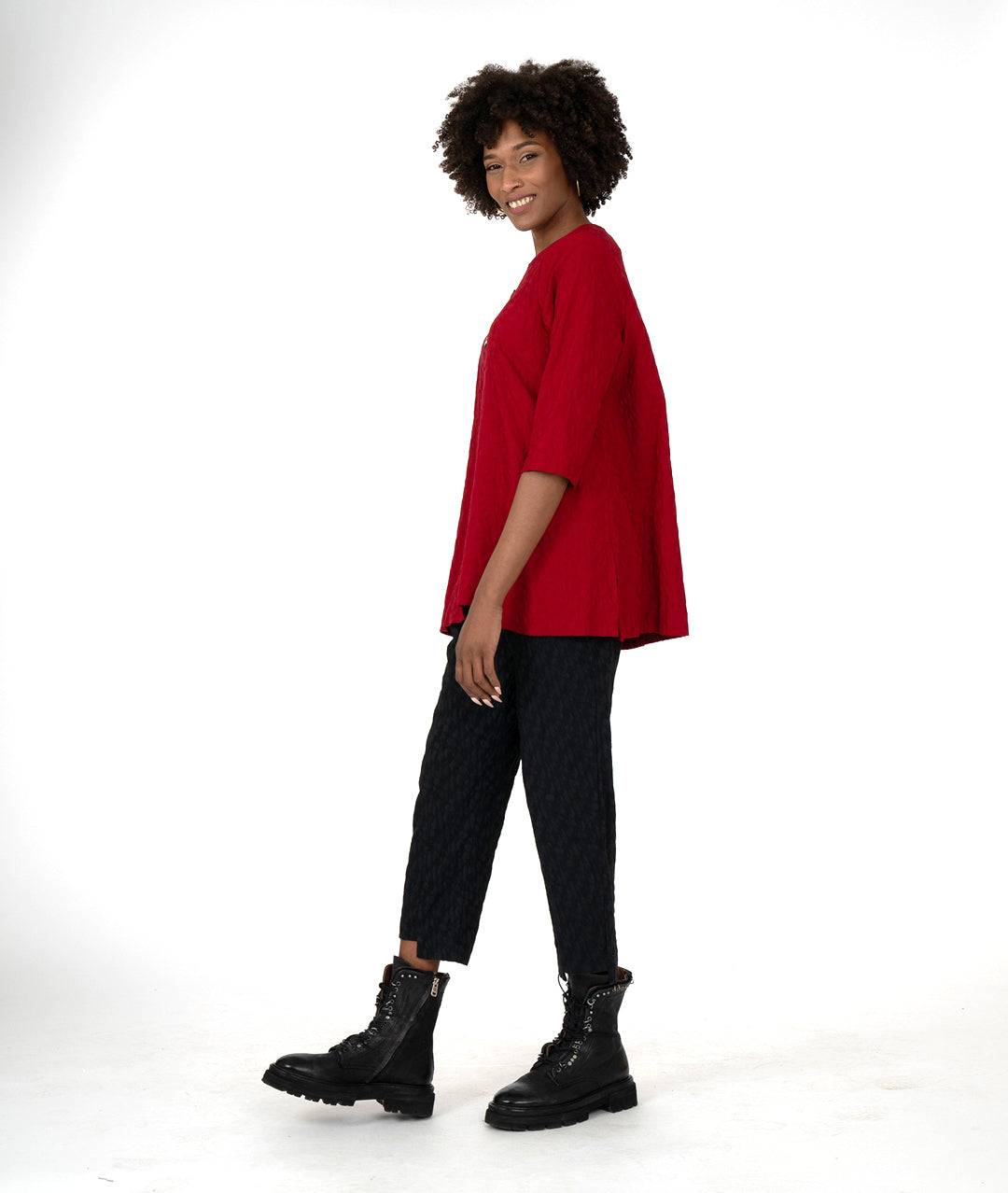 model in a black slim pant and red top, both with asymmetrical hems