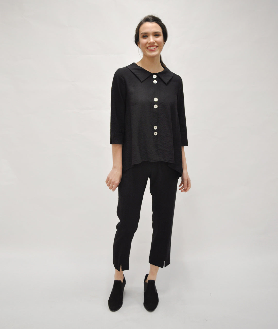 model in a slim black pant with a black button up blouse