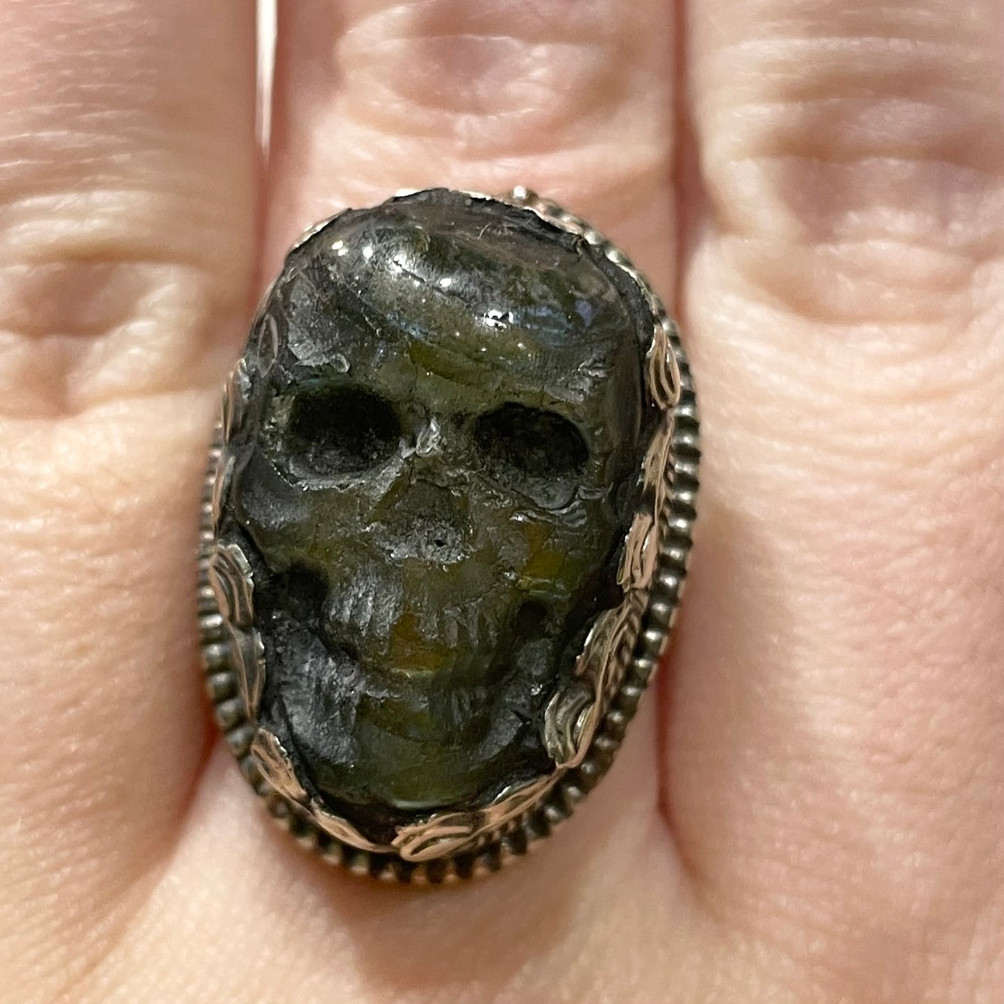 Skull carved Green Labradorite set in detailed Tibetan Silver ring on a model's finger