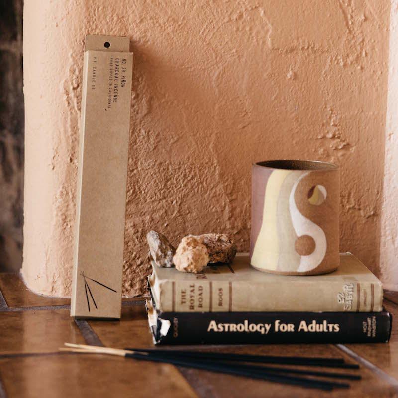 a few books with a small pile of incense in front of them\