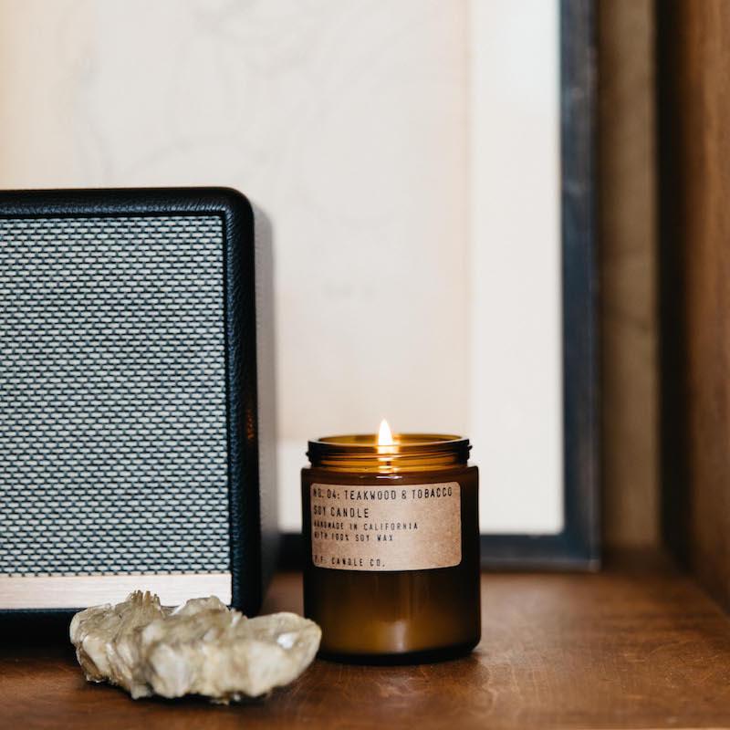 candle in an amber colored jar on a desk