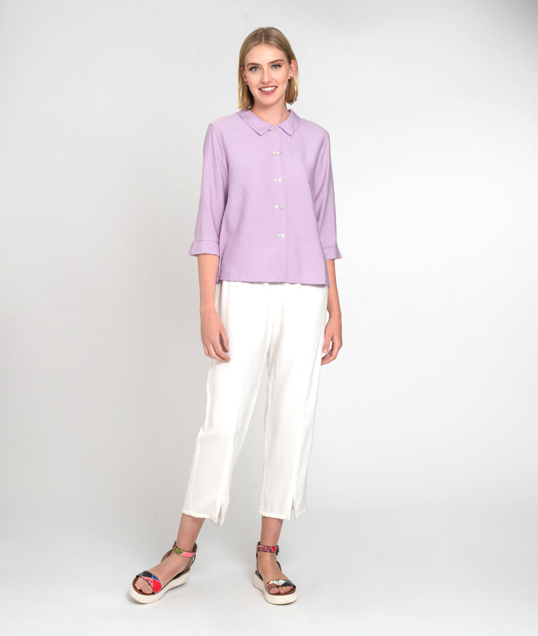 model in a slim white pant with a lilac color button down blouse with a 3/4 sleeve