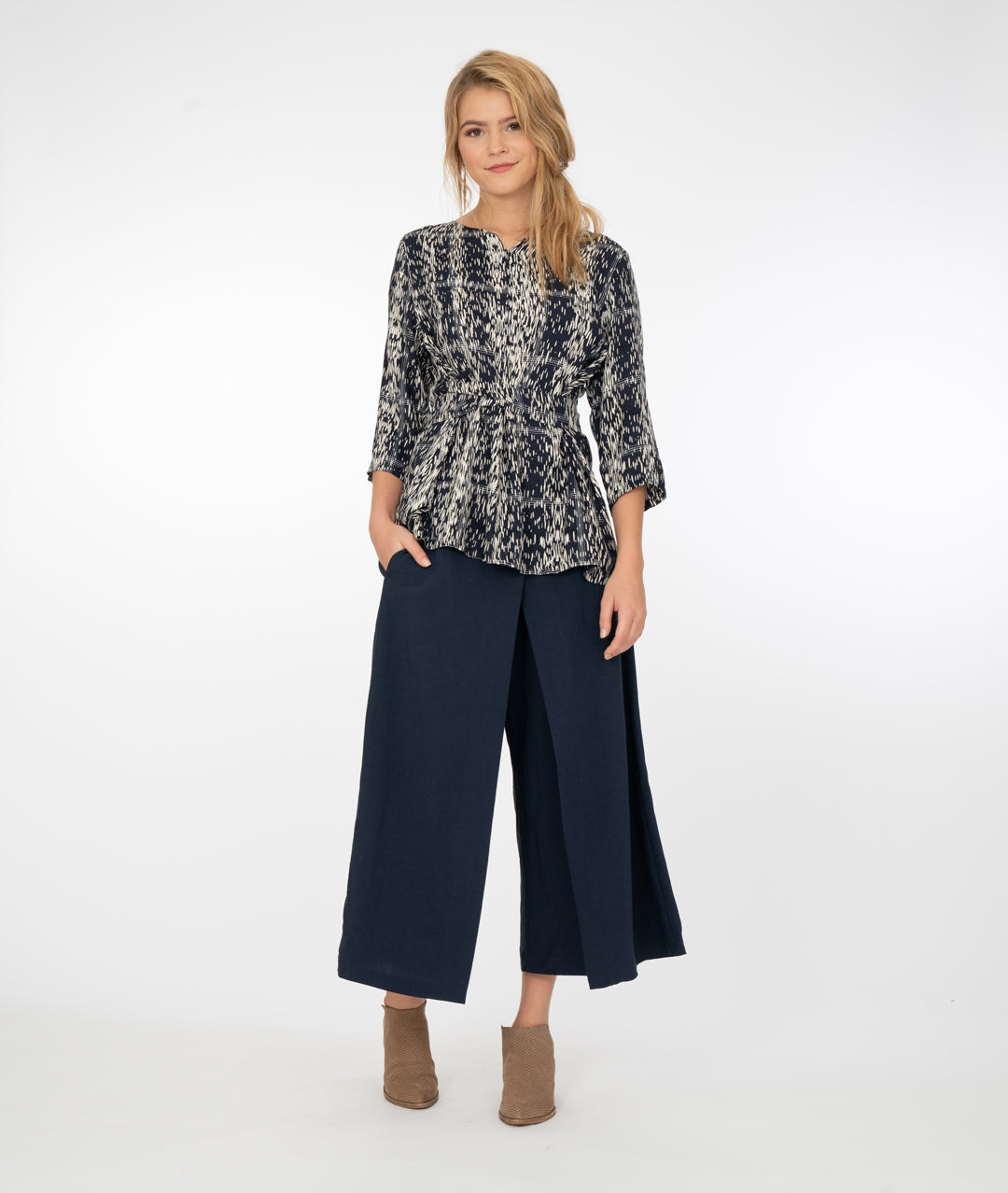 model in wide, navy pants with a blue and ivory print top