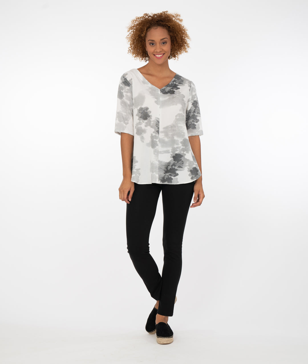 model in a black pant with a grey and white print vneck top