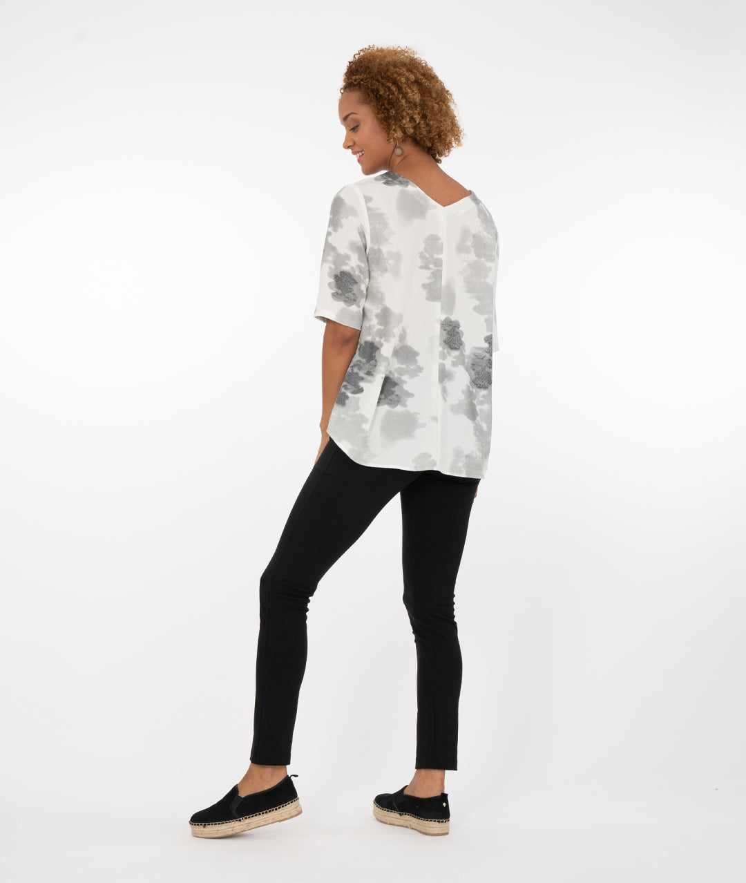 model in a black pant with a grey and white print vneck top