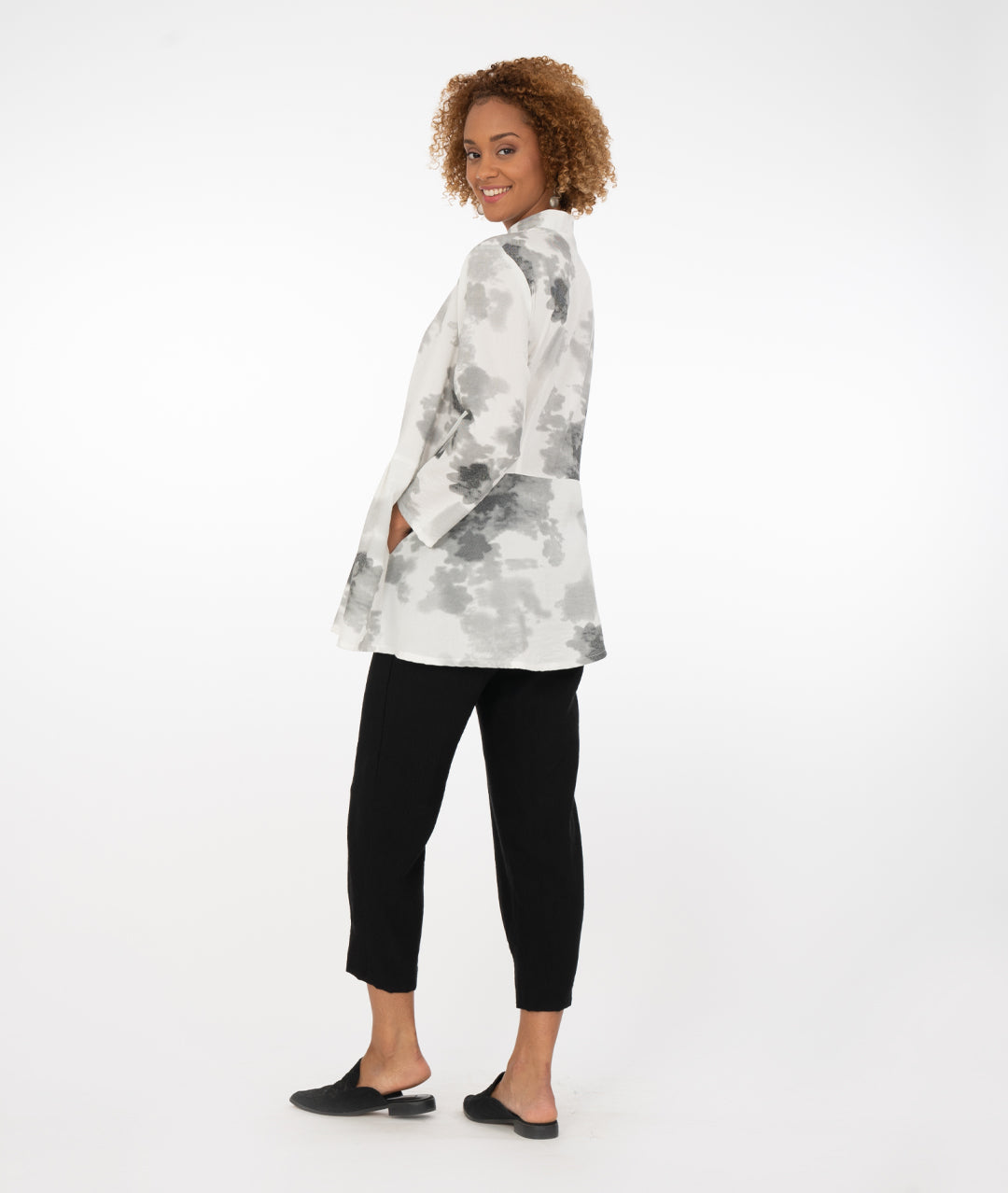model in a black pant with a white and grey cloud print blouse with an asymmetrical hem and body