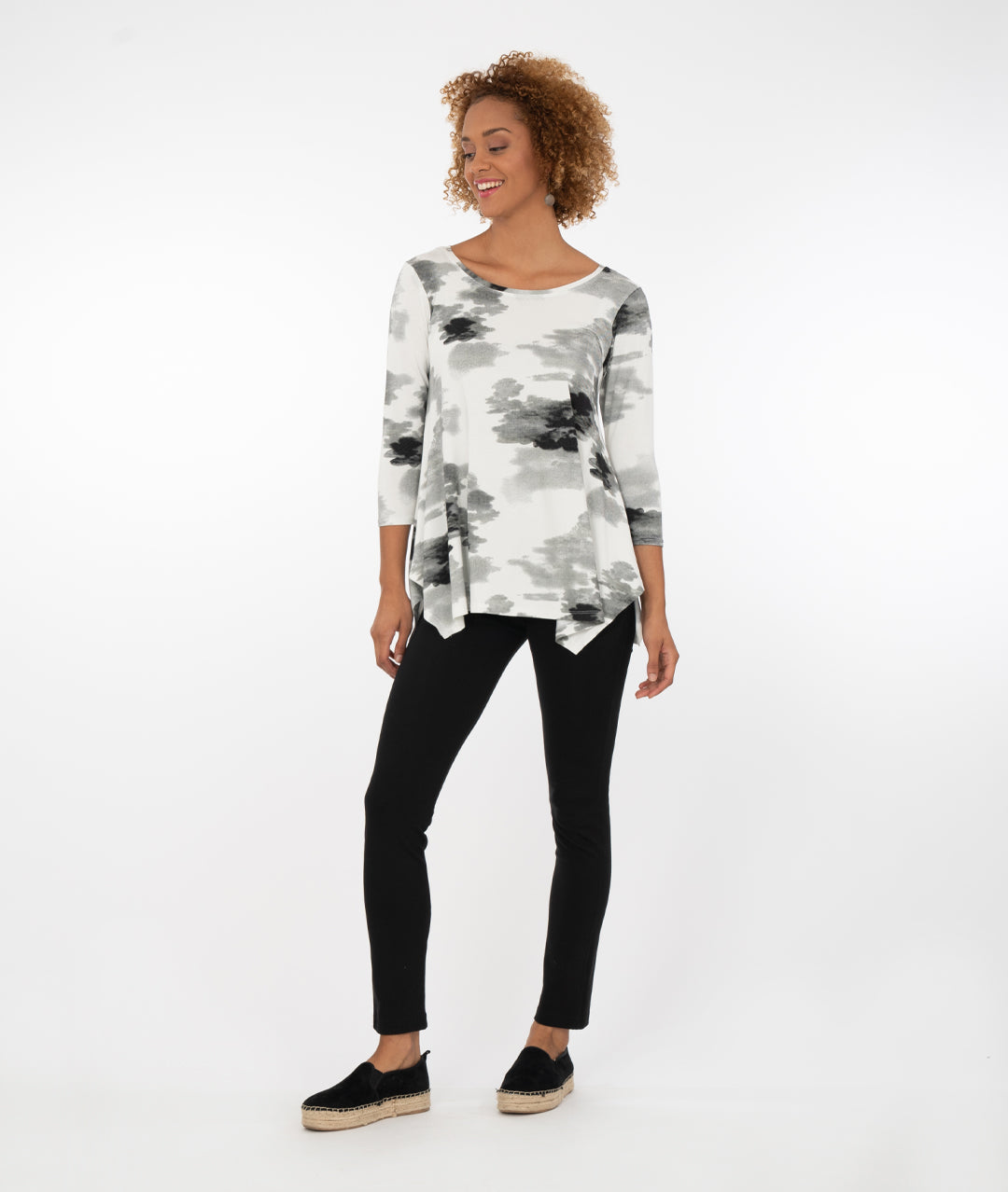 model wearing a black and white floral  top with black leggings in front of a white background