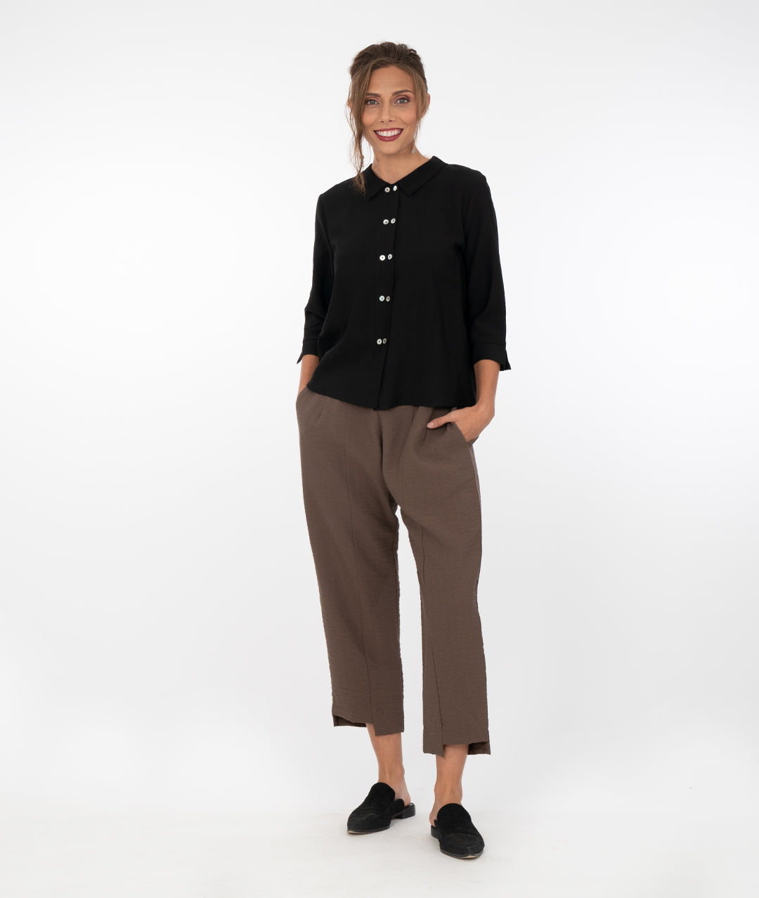 model in a cropped brown pant with a black button down blouse with 3/4 sleeves
