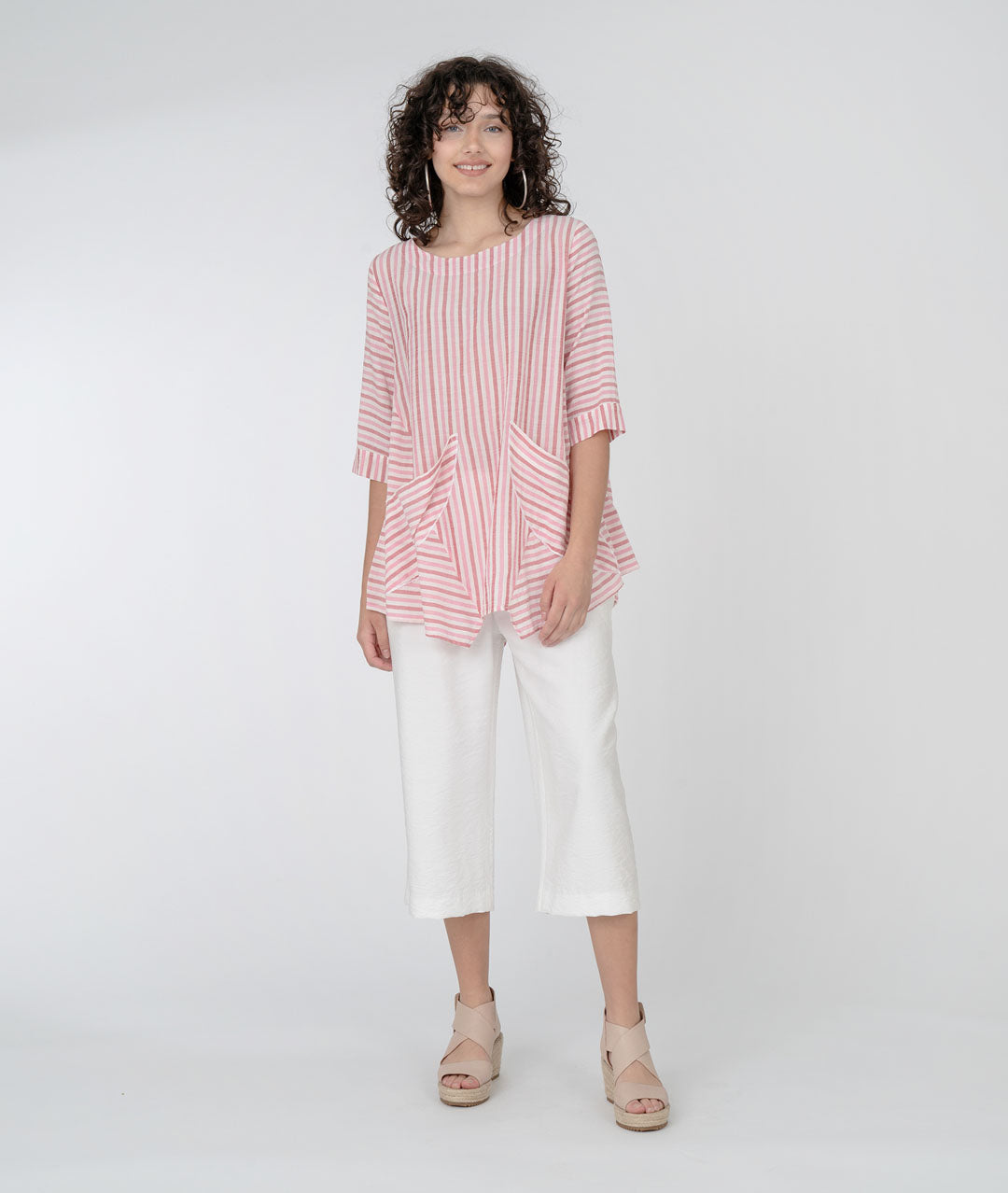 model in a white wide leg crop pant with a white and red wide stripe pullover top with half moon pockets at either hip, and 3/4 sleeves