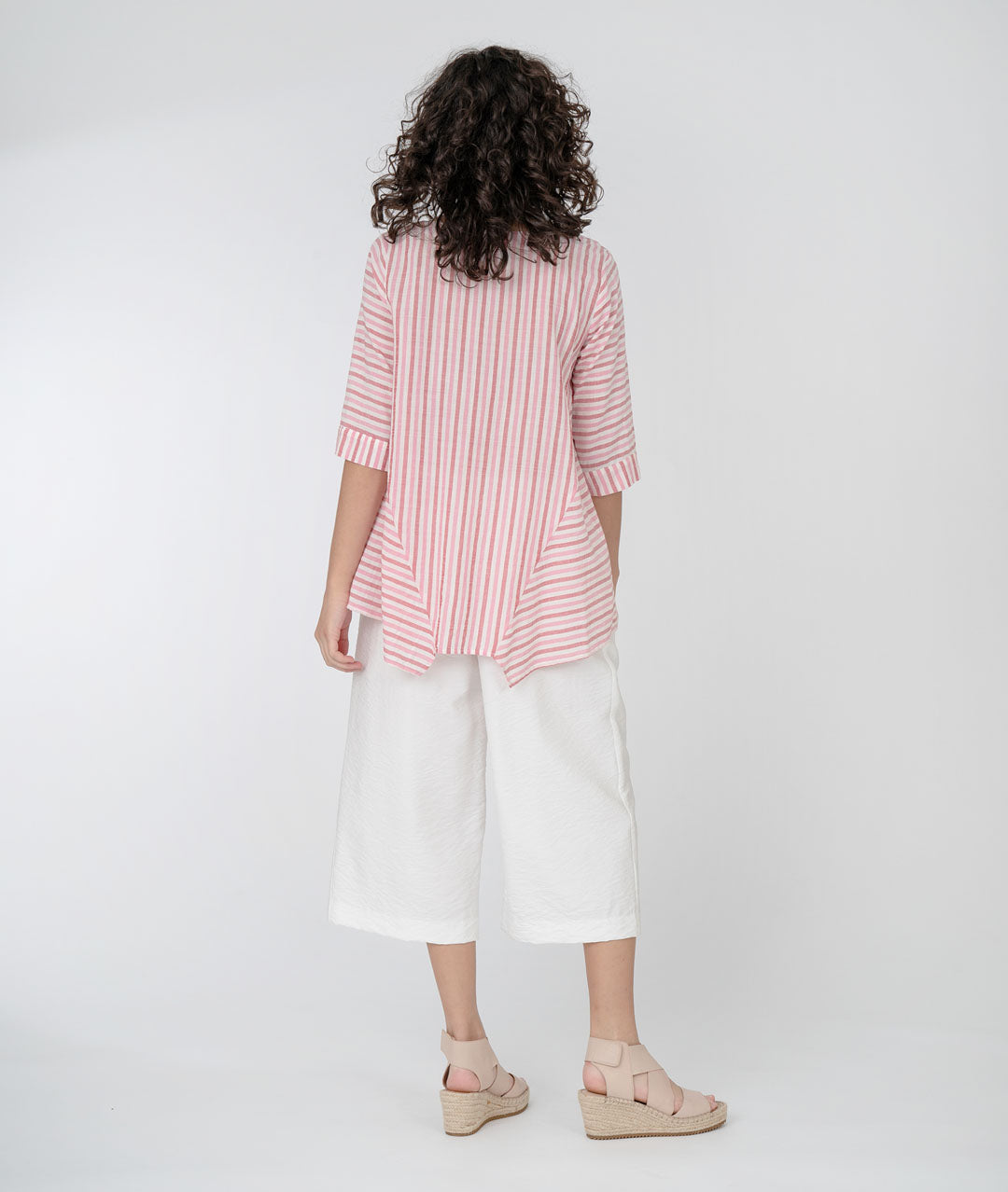 model in a white wide leg crop pant with a white and red wide stripe pullover top with half moon pockets at either hip, and 3/4 sleeves
