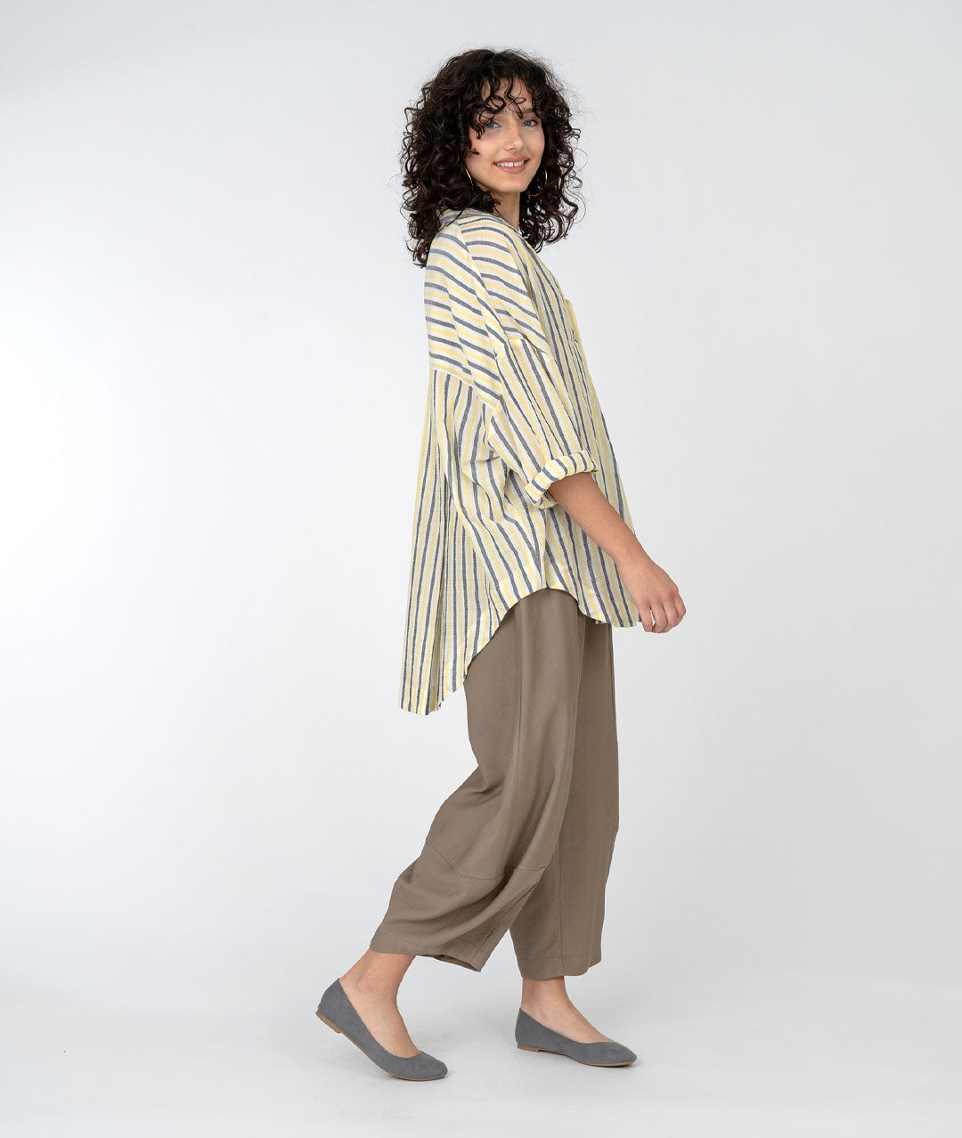 model in a wide leg brown pant with a yellow, grey and white striped collared blouse