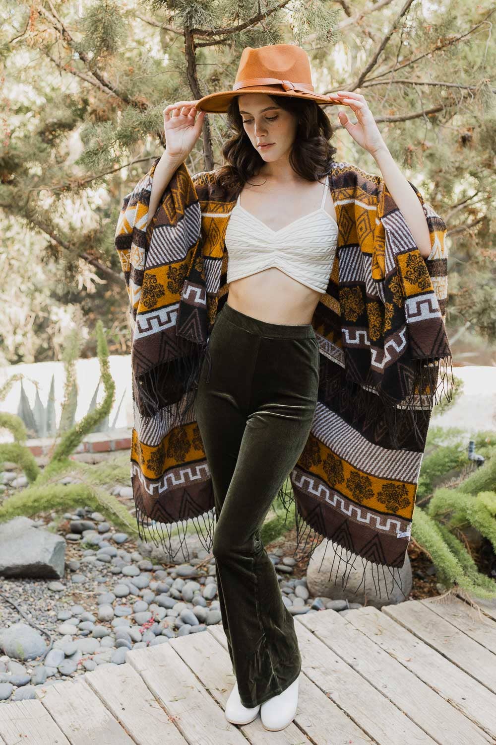 model is wearing an Aztec-printed ruana in an outdoor setting