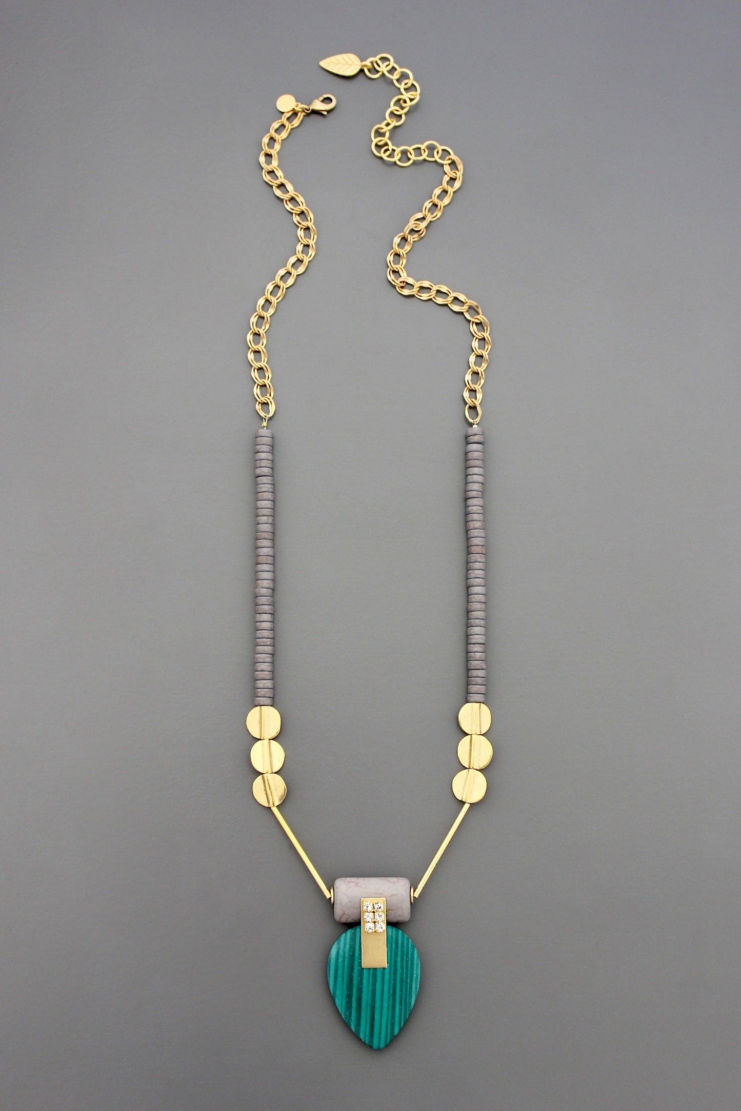 24” necklace with 18k gold plated brass clasp and double curb chain, magnesite, synthetic malachite, glass rhinestones, and brass against a grey background