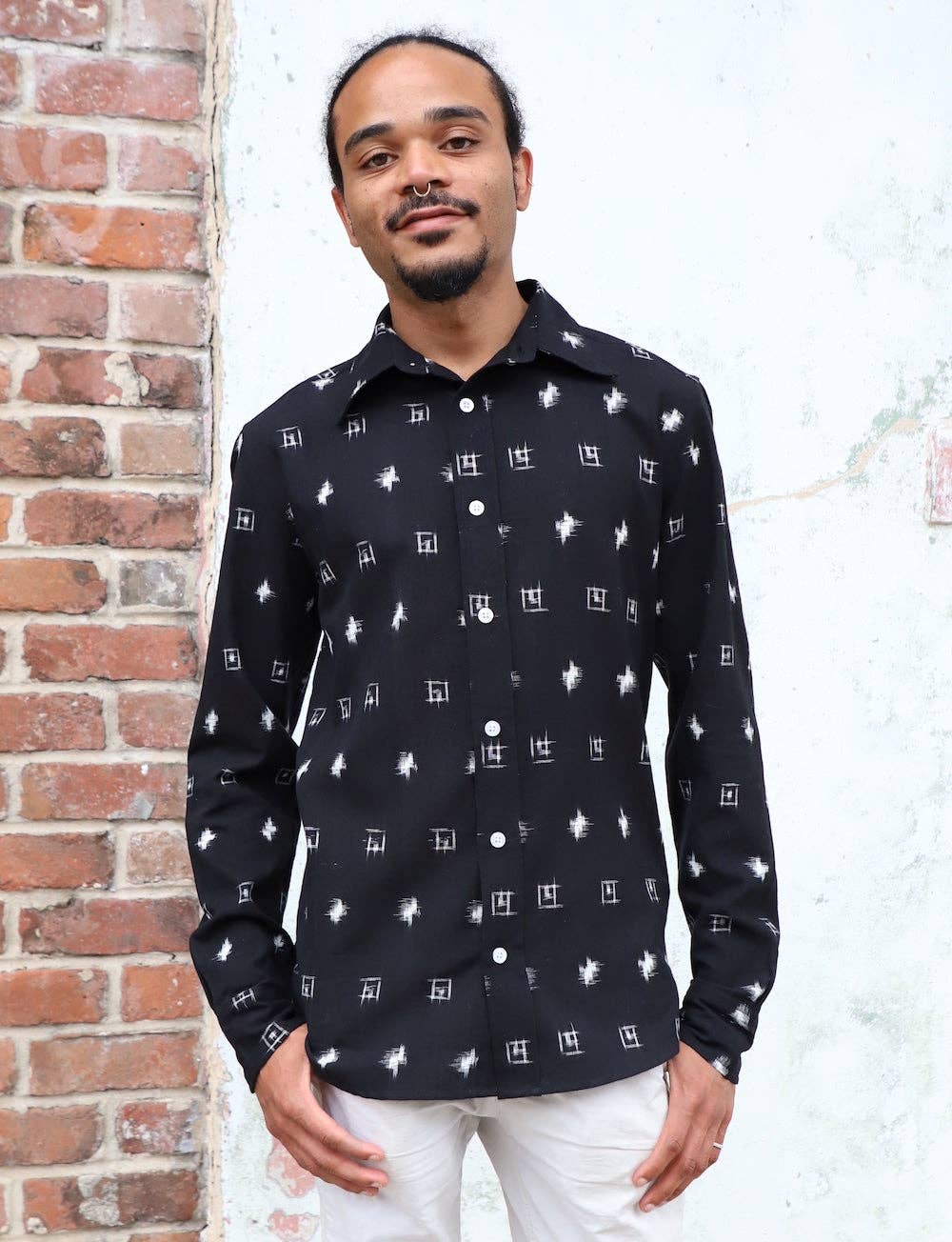 model wearing longsleeve black button up shirt with white designs