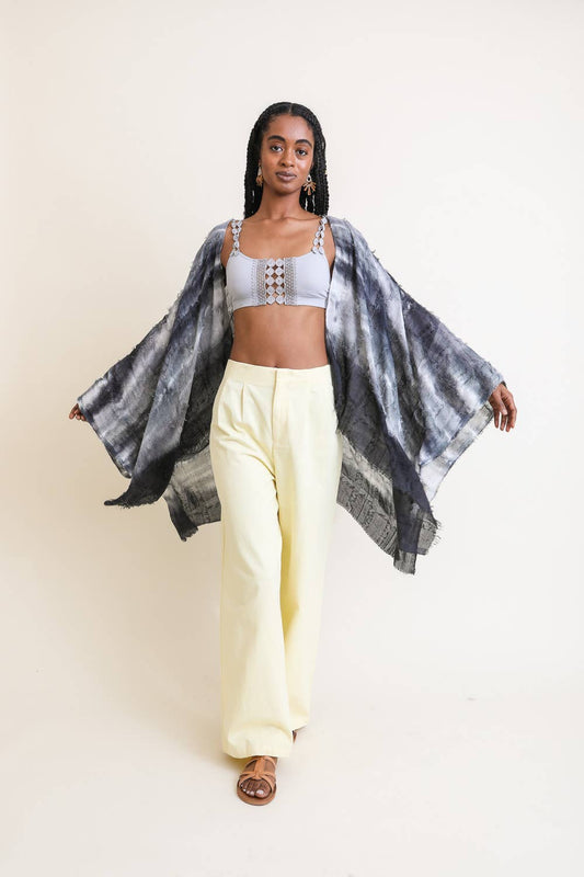 model is pictured against a white background wearing yellow trousers, a grey kimono, and on off-white bralette