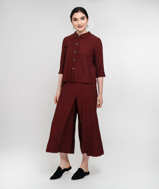 model in a maroon button up top with a wide leg dark maroon pant