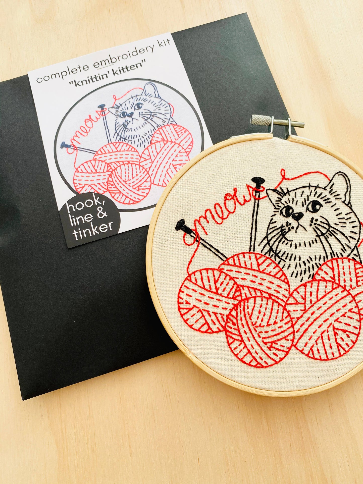 envelope and embrodery hoop with a kitten and yarn design
